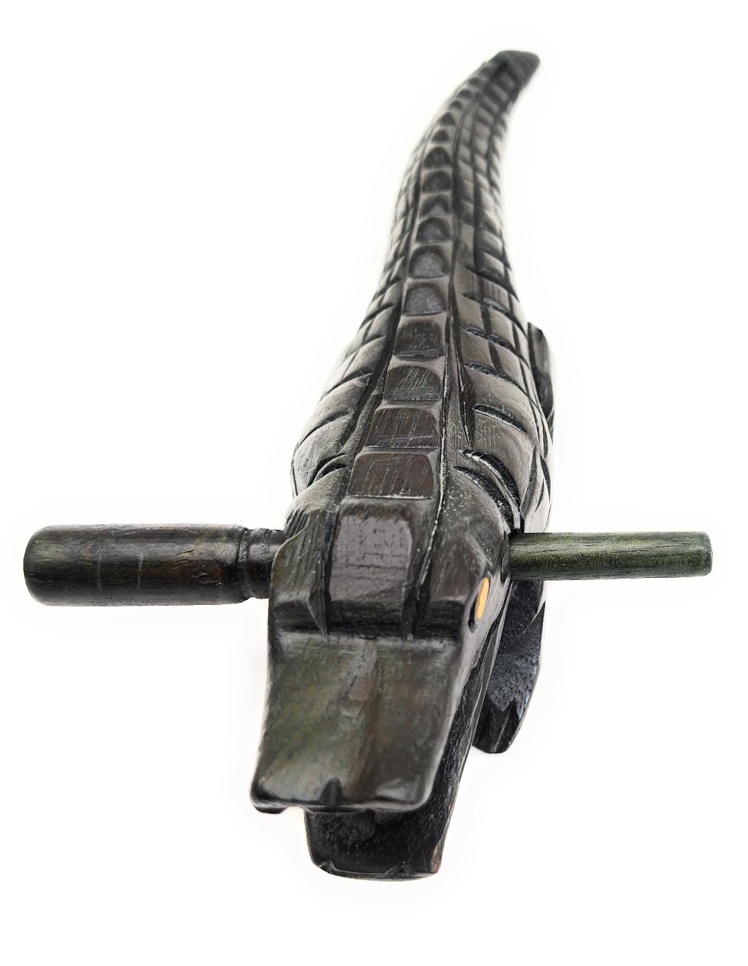 Wooden Croaking Alligator musical instrument carved dark green wood with mallet for drum rasp sound effect.