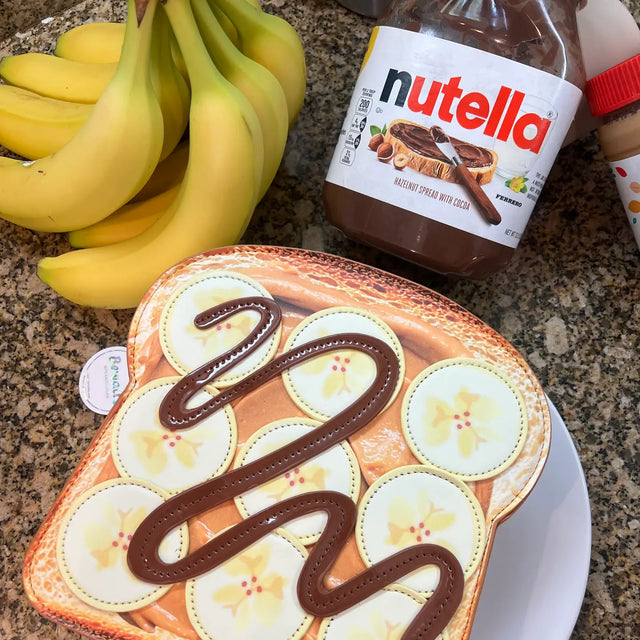 Handbag | Banana Peanut Butter Toast crossbody with banana slices and peanut butter design on golden toast base.