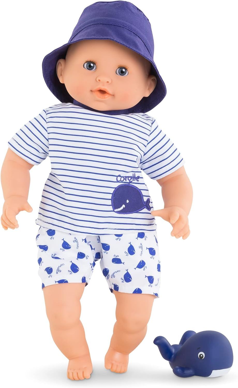 Bath Baby Marin doll in striped shirt, whale print shorts, purple hat, with blue whale toy, ready for water play.