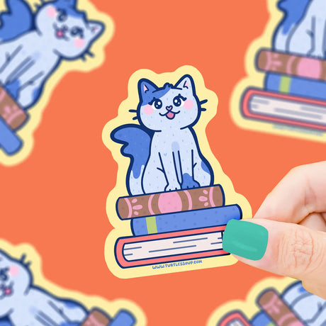 Cat on Stacked Books Sticker showing a cute blue cat sitting on colorful books, printed on durable vinyl for lasting use.