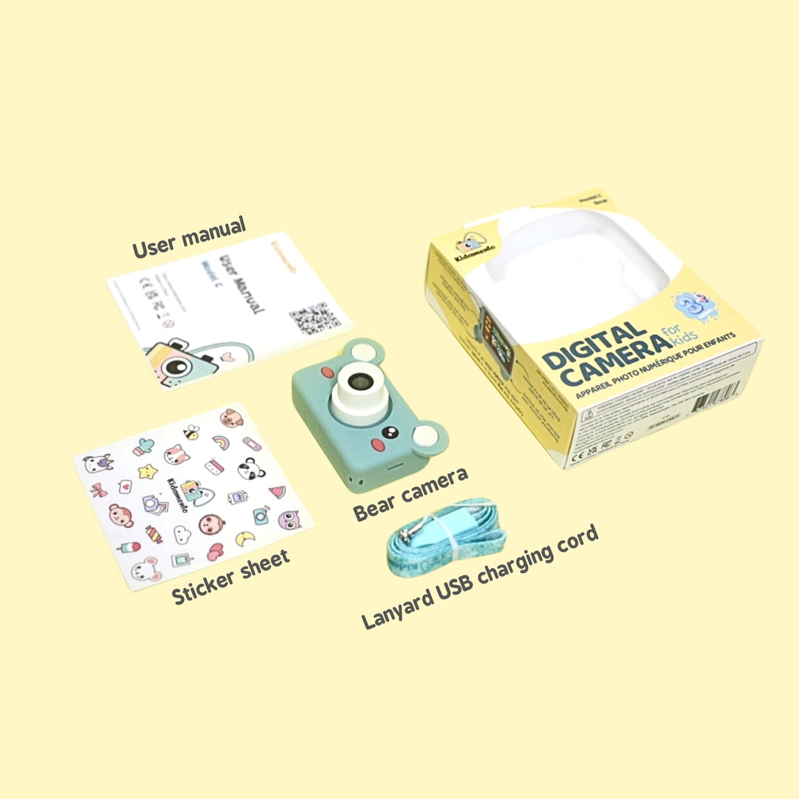 Digital Camera Model C Mikayo the Bear with camera, sticker sheet, USB cord, user manual, and packaging box on yellow background