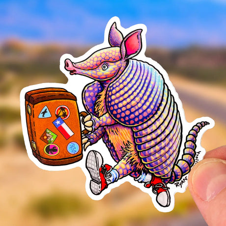 Sticker of Travelling Armadillo holding a suitcase with travel stickers, durable, waterproof, and UV protected.