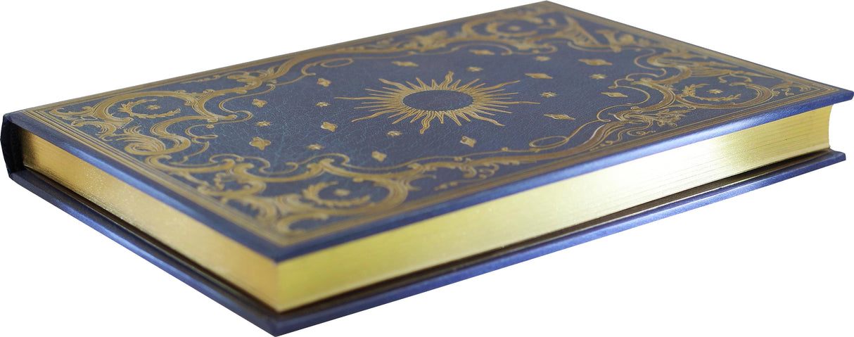 Hardcover journal with gold foil celestial design and gilded edges, lying closed on a white background