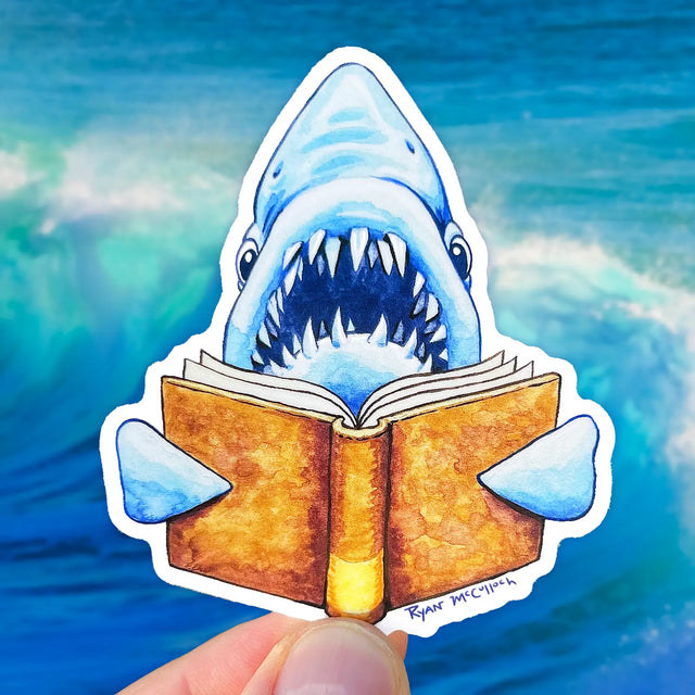 Book Shark Sticker featuring a blue shark reading a book, durable, waterproof, and U.V. protected by Ryan McCulloch.