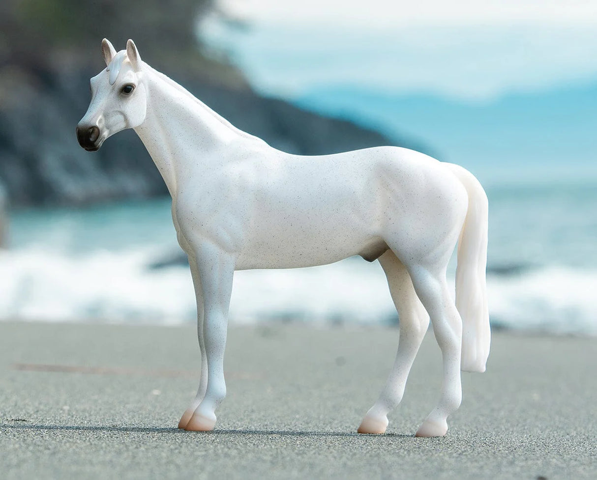 Fleabitten Grey Thoroughbred model horse standing outdoors with detailed athletic build and lifelike features.