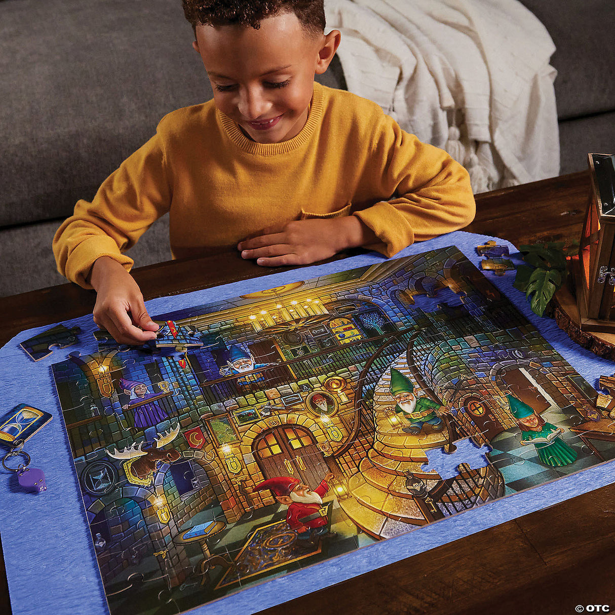 Child assembling the PZ 100pc Seek&Find Gnomes puzzle featuring a detailed glowing gnome scene on a table.