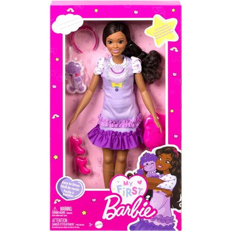 My First Barbie Black Hair doll in lilac dress with pink shoes and headband, designed for easy play and dressing.