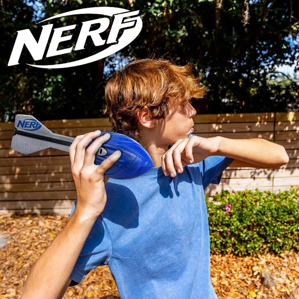Child playing outdoors throwing a Nerf Aero Vortex Howler foam football with flight-optimizing tail.