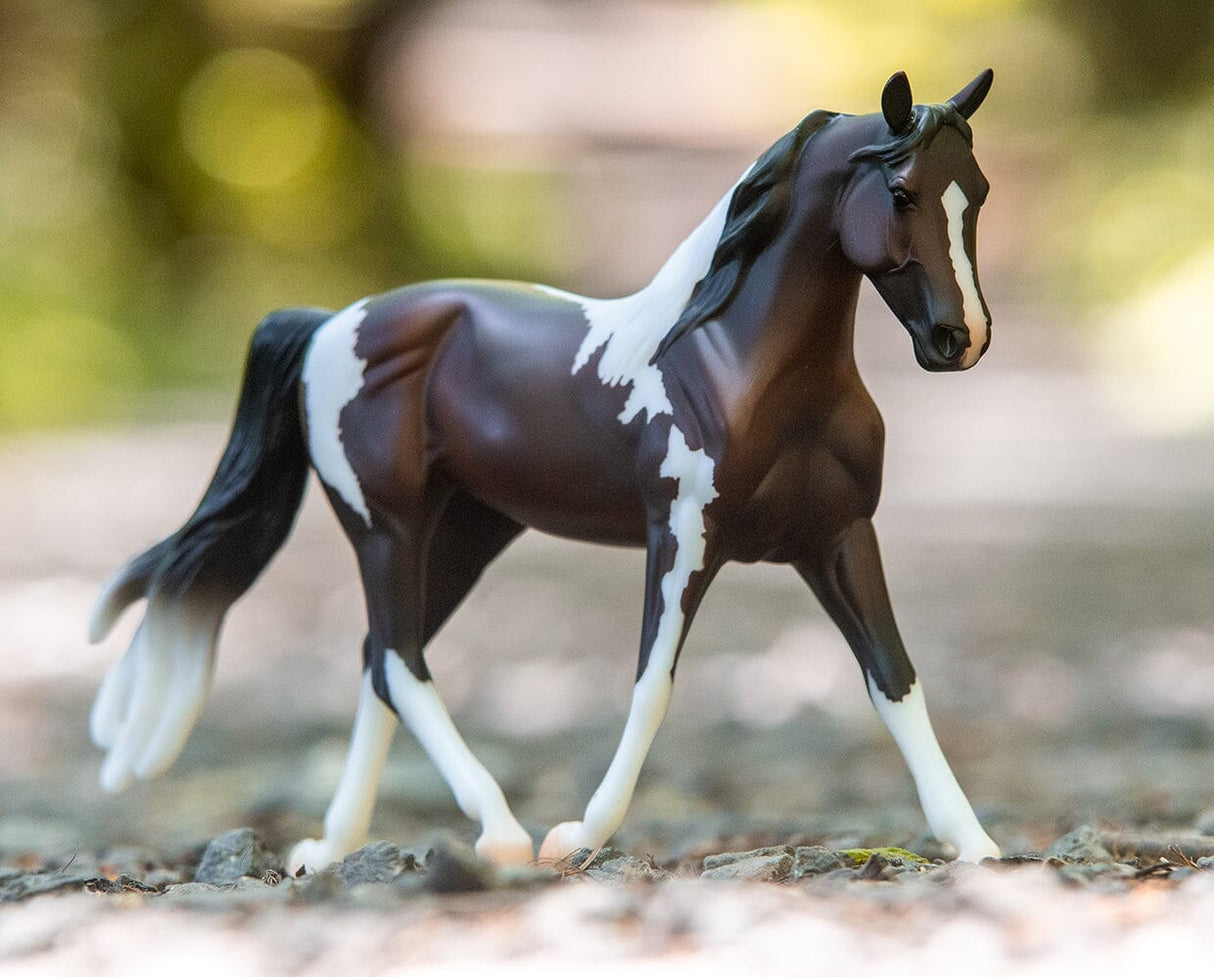 Pinto model horse in 1:12 scale from Freedom Series with detailed colorful coat and dynamic walking pose.