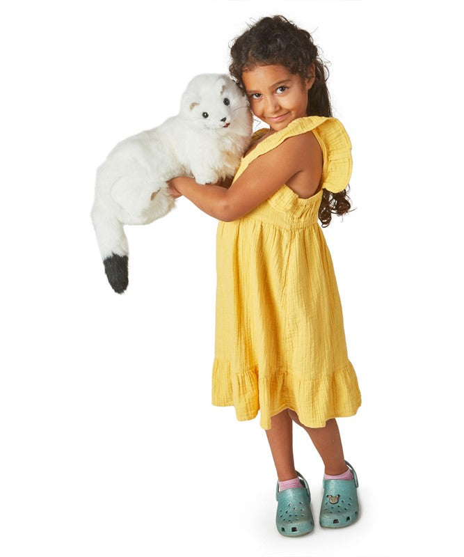 Young girl in yellow dress holding a white Ermine Puppet with black tipped tail and movable mouth.
