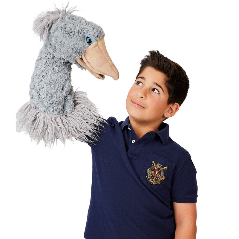Child playing with a Shoebill Bird Stage Puppet in gray-blue feathery plush with expressive eyes and lifelike details.