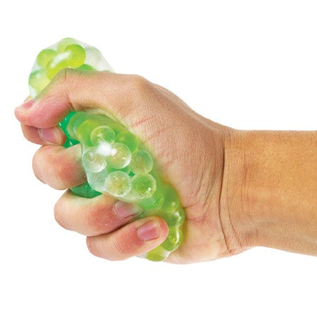 Hand squeezing a glowing Light-Up Frog Egg Ball filled with realistic frog eggs for fun sensory play.