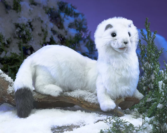 Ermine Puppet plush with white fur and black tipped tail posed on snowy branch in winter scene.