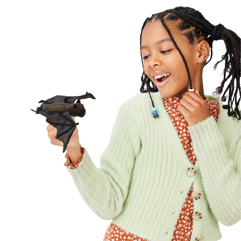 Girl playing with a Bat Finger Puppet, showing detailed wings and a sweet face for imaginative storytelling.