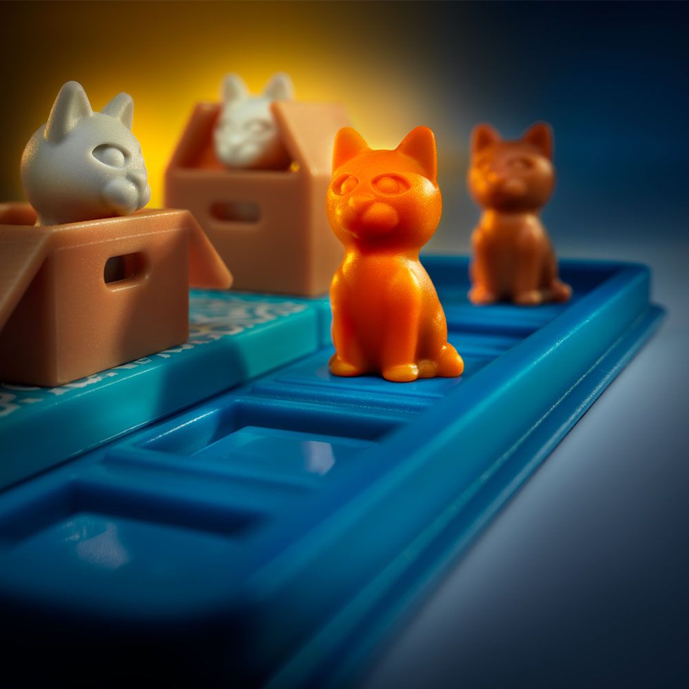 Cats & Boxes game pieces showing colorful cats and boxes arranged on a blue puzzle board in soft lighting.