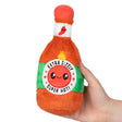 Hand holding Hot Sauce Snackers plush toy with smiling face and fiery pepper design, soft polyester fiber.