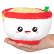Ramen Snackers plush toy bowl with smiling face and noodle details held in hand, soft polyester fiber plush.