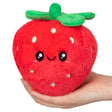 Soft and cuddly Strawberry Snackers plush toy with a friendly smile and bright green leaves held in hand