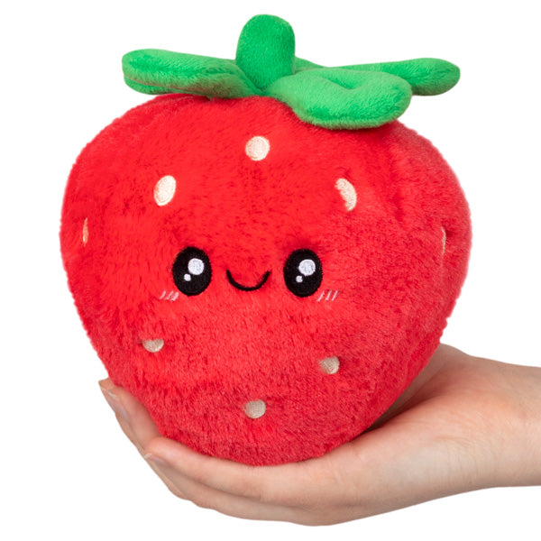 Soft and cuddly Strawberry Snackers plush toy with a friendly smile and bright green leaves held in hand