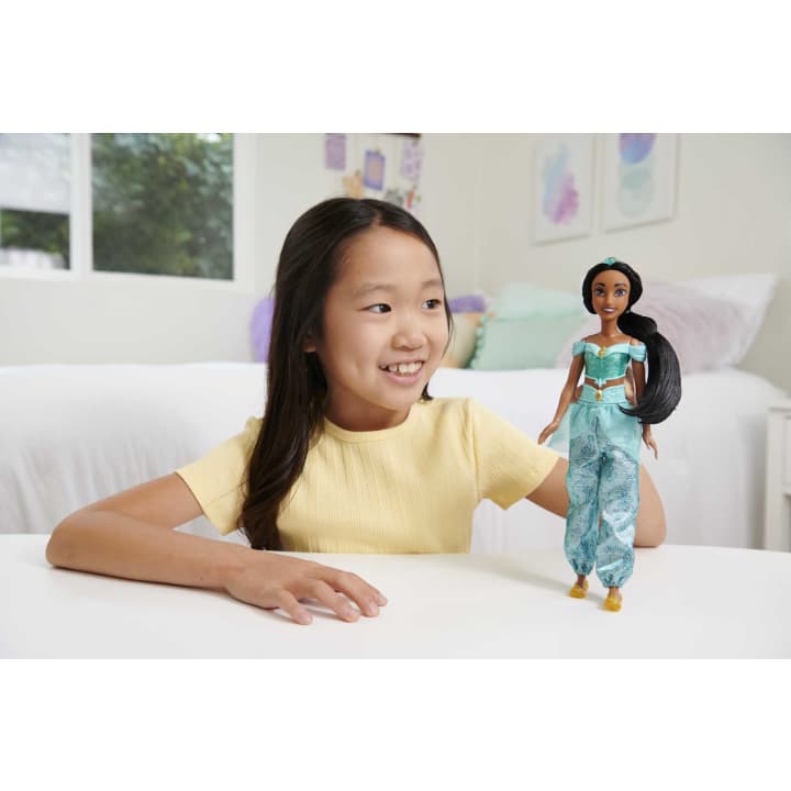 Disney Princess Jasmine doll with removable tiara and shoes being played with by a smiling child indoors.