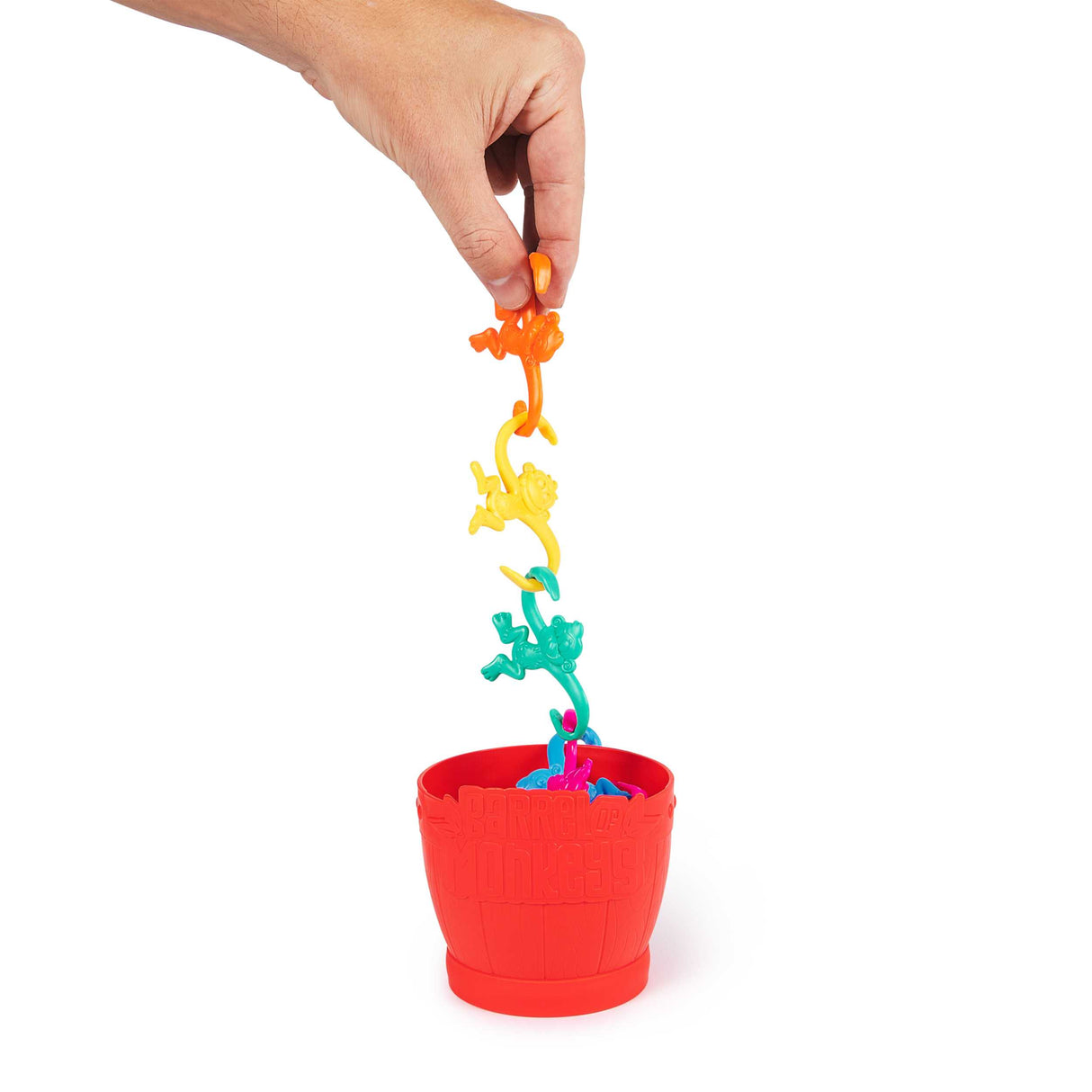 Hand linking colorful monkeys above red barrel in the classic game Barrel of Monkeys for all ages and fun play.