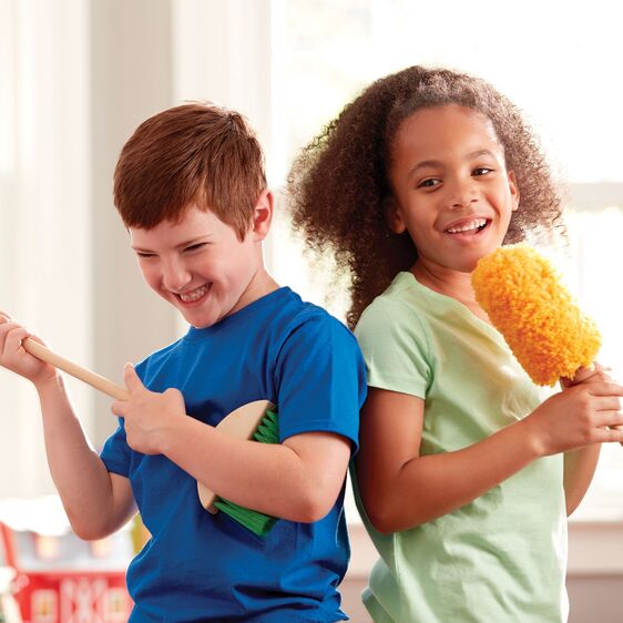 Two kids happily playing with cleaning tools from the Dust Sweep & Mop Set in a bright room.