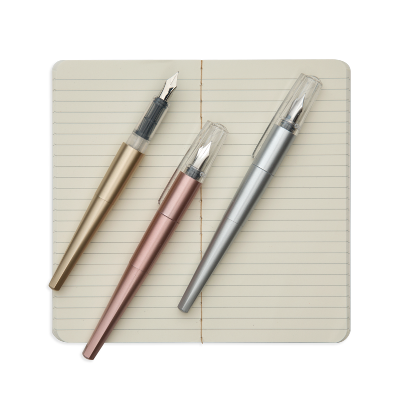 Modern Script Fountain Pens set with gold, rose gold, and silver pens on an open lined journal page.