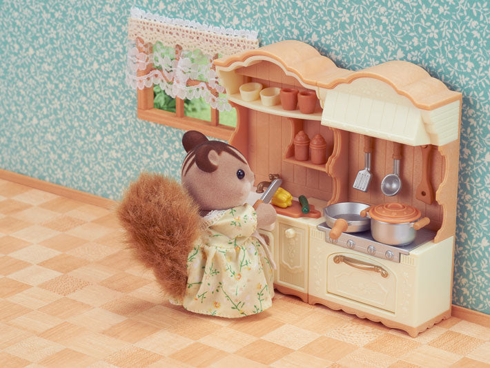 Kitchen Play Set with stove, sink, utensils, and shelves featuring a small animal doll cooking in a cozy room.