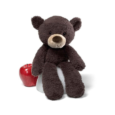 Teddy Bear Fuzzy Chocolate plush with floppy arms and legs sitting next to a red apple on white background.