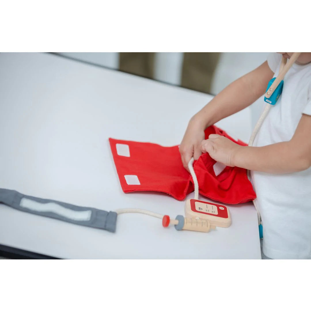 Child playing with red doctor case and medical tools in the Doctor Set for pretend play and learning empathy.