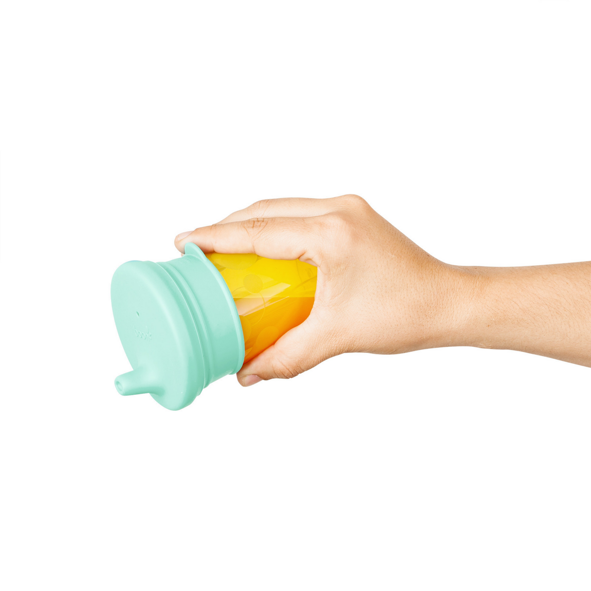 Hand holding a yellow cup with a green SNUG Spout Sippy Lids Greens silicone spill-proof lid attached.