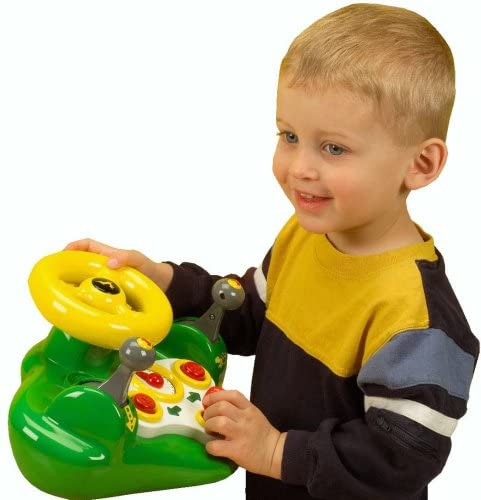 Child playing with the interactive John Deere Busy Driver tractor toy steering wheel and buttons for ages 1 and up.