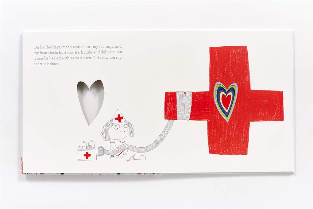 Open page of "In My Heart" book showing a red cross with a heart-shaped cutout and a nurse illustration.
