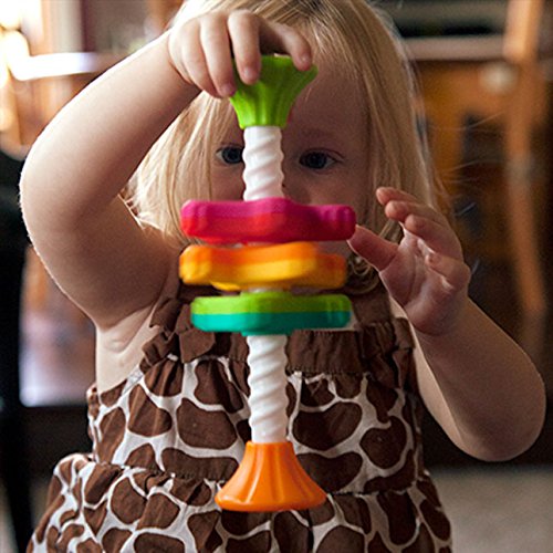 Toddler playing with colorful MiniSpinny toy featuring vibrant propellers on corkscrew pole for sensory play.