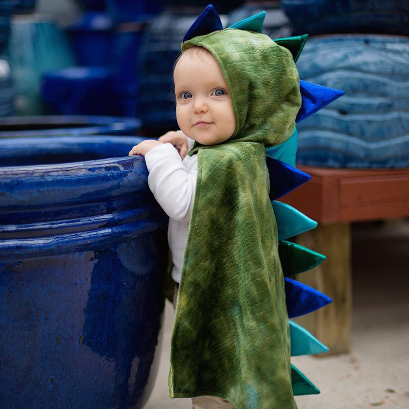 Baby wearing Baby Dragon Cape | Size 2-3 in soft green crushed velvet with foam spikes and Velcro neck closure.