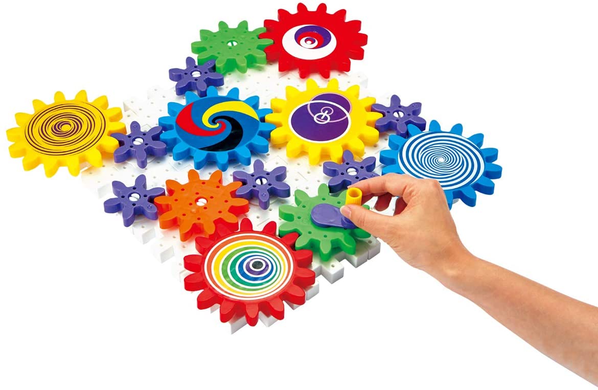 Hand placing colorful interlocking gears with vibrant stickers on white base in Kaleido Gears educational toy set.
