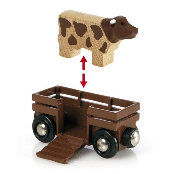 Farm Railway Set wooden cow being placed onto brown wagon with fold-out ramp for farm animal transport play.