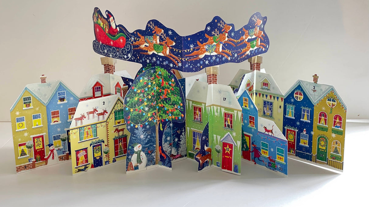 Santa's Rooftop 3D Advent Calendar showing a colorful Christmas town with Santa's sleigh flying above.