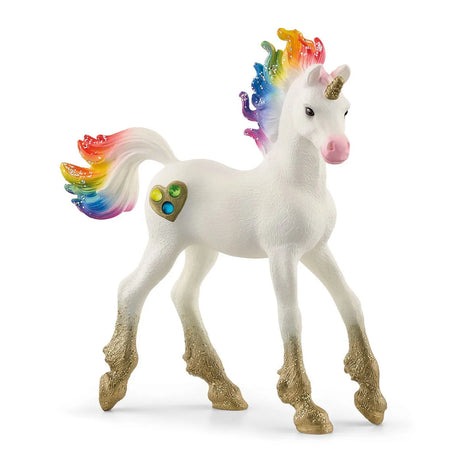 Bayala | Rainbow Love Unicorn Foal with rainbow mane, golden glitter hooves, and a sparkling horn standing on white background.