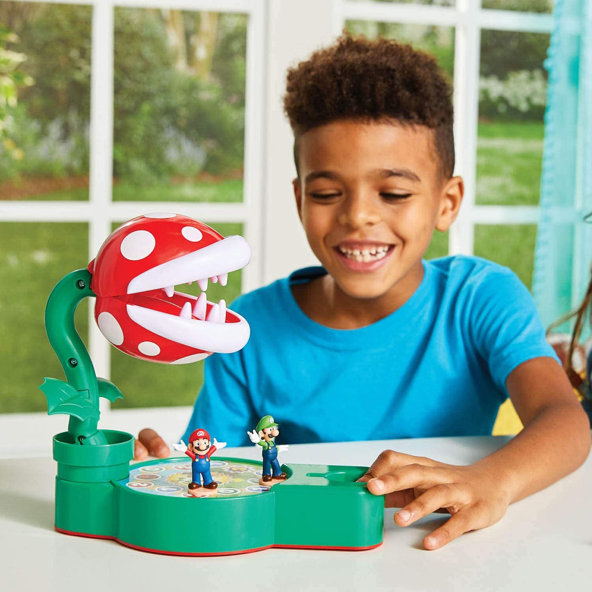 Child playing with Super Mario Piranha Plant Escape! game featuring Piranha Plant and Mario and Luigi figures on board.