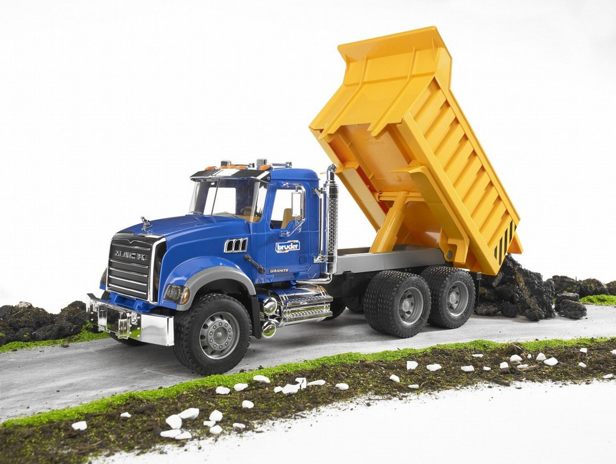 Mack Granite Tip Up Truck with realistic cabin, tilting bonnet, and yellow tip-up bed on a dirt road model display.