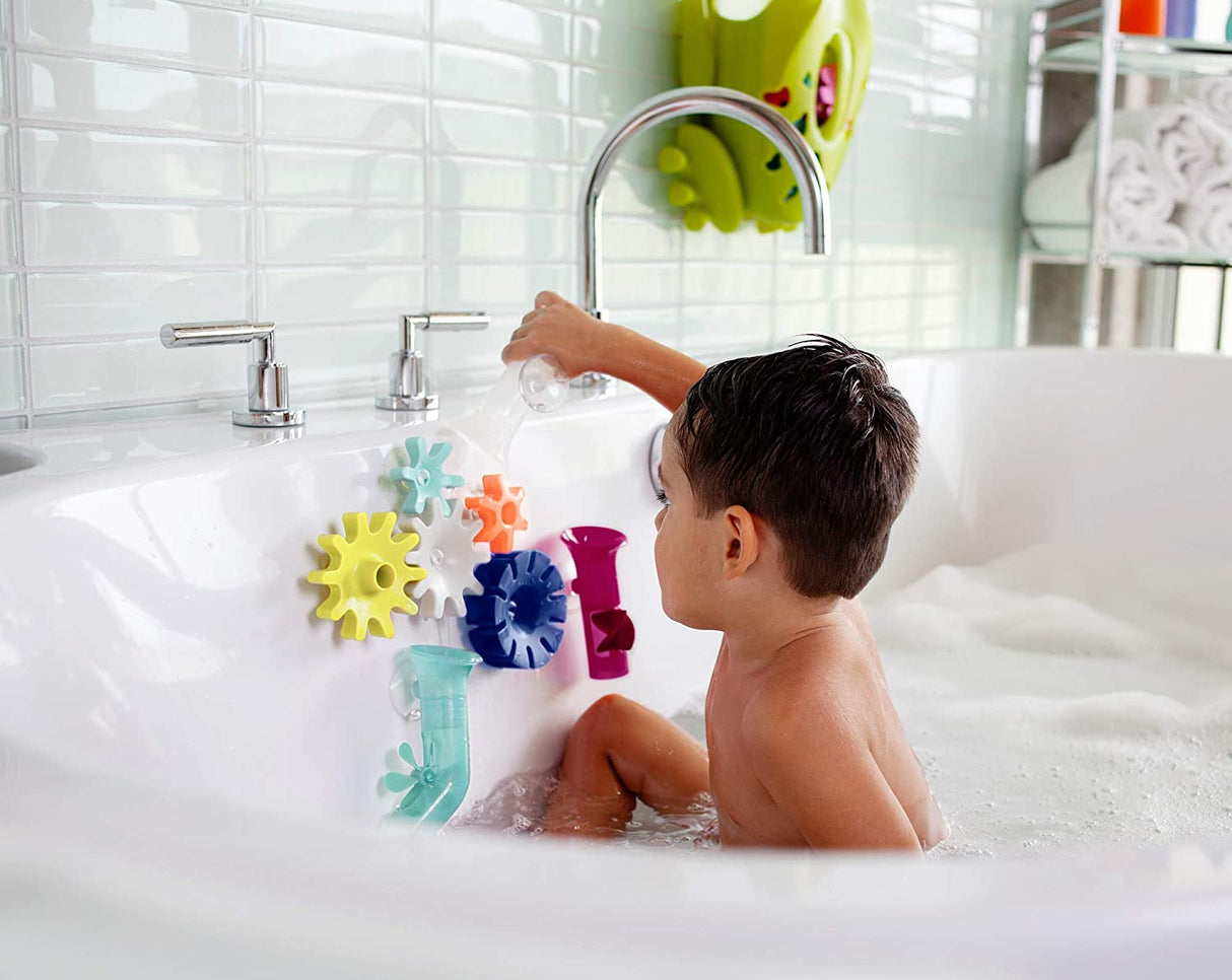 Child playing with colorful spinning COGS Water Gears attached to bath wall during bath time fun.