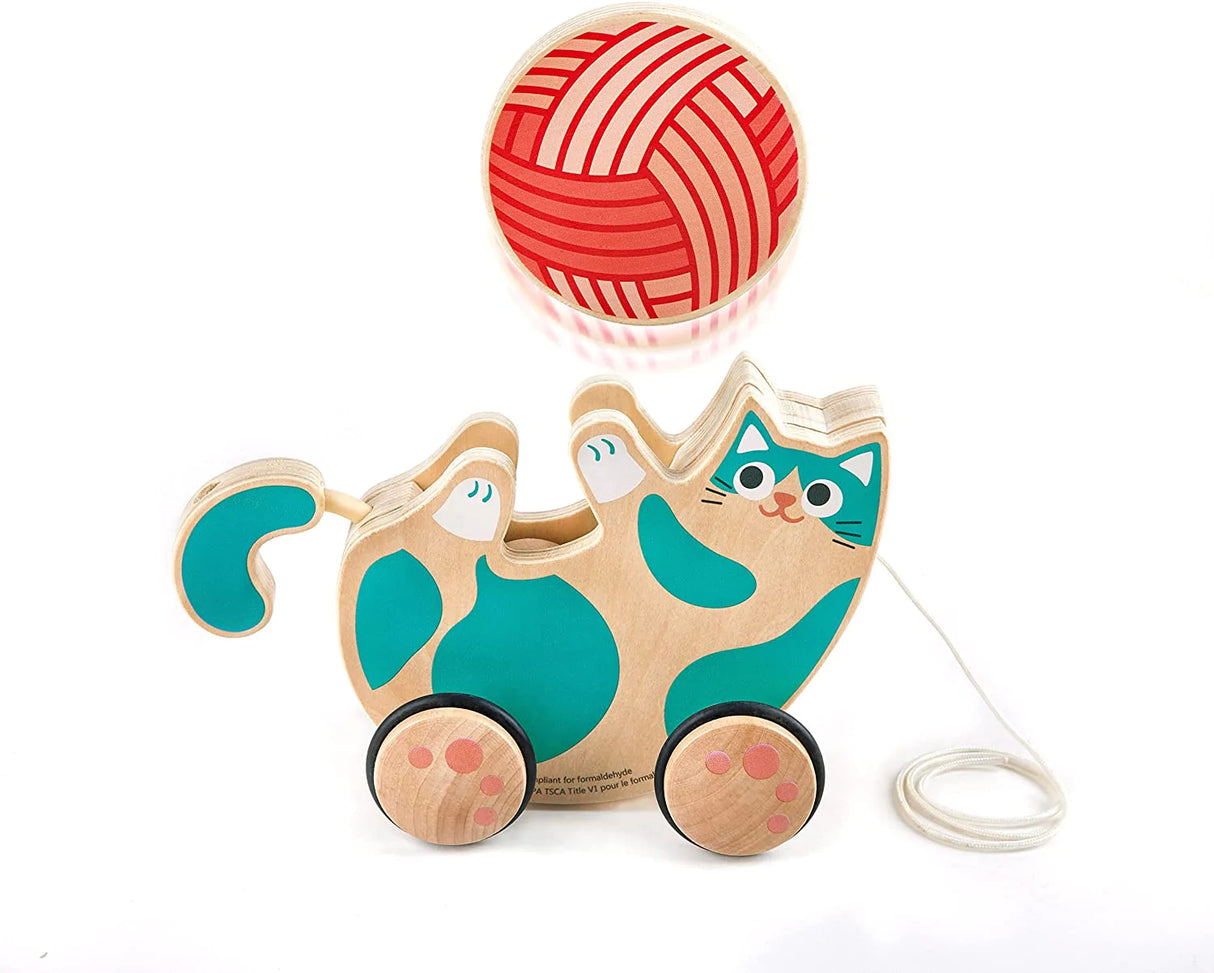 Wooden Pull Along Roll & Rattle Kitten toy with teal spots, wheels, and a red wool rattle ball on a string.