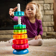 SpinAgain stacking toy with vibrant, dual-colored discs spinning on a corkscrew pole on a reversible wobble base.