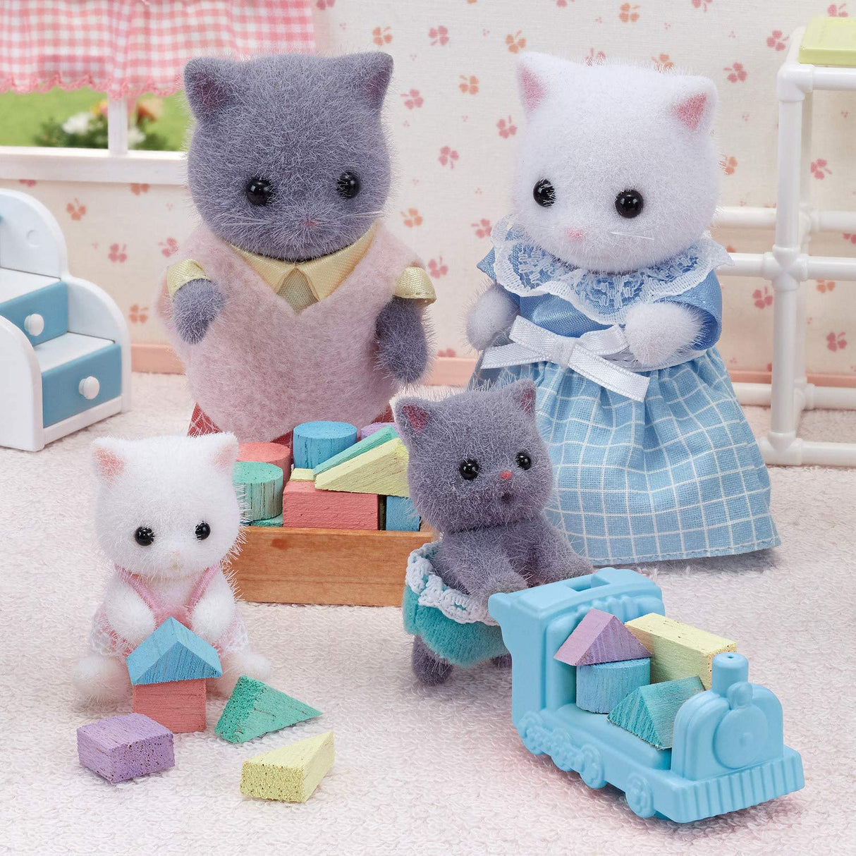 Persian Cat Twins with two fluffy babies in fabric clothes and a pastel ride-on toy for imaginative play.