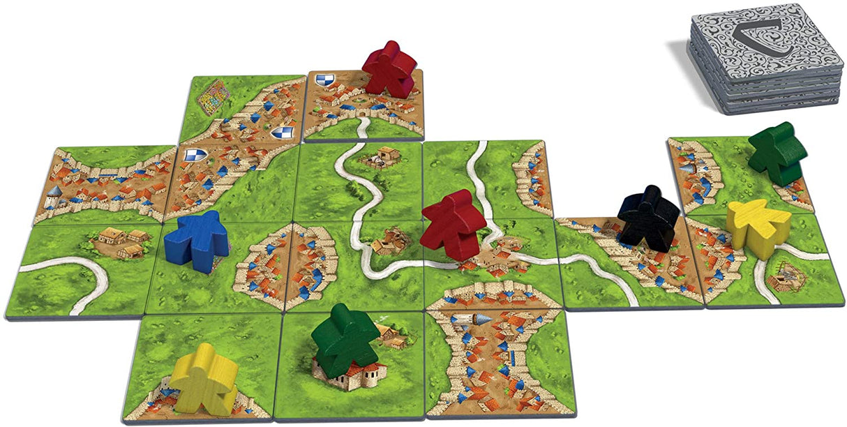 Carcassonne board game tiles and colorful follower pieces creating a medieval landscape for strategic play.