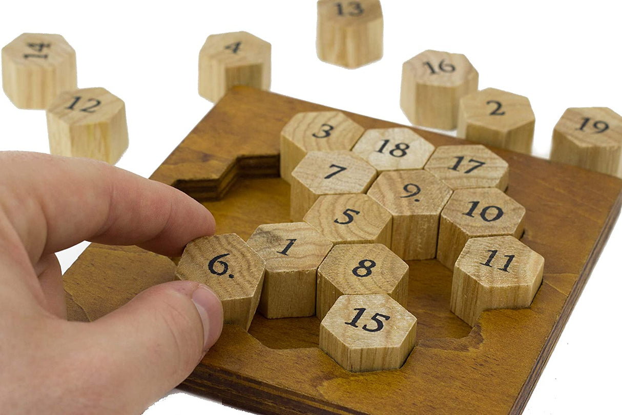 Hand arranging numbered wooden pieces on the Aristotle Number Puzzle brainteaser game board.