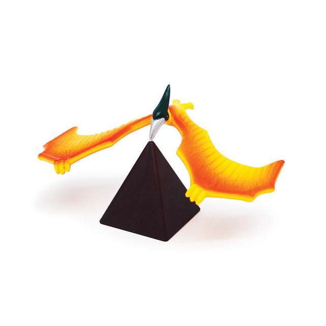 Balancing Pterosaur toy perched on black pyramid stand illustrating balance and center of gravity for kids.