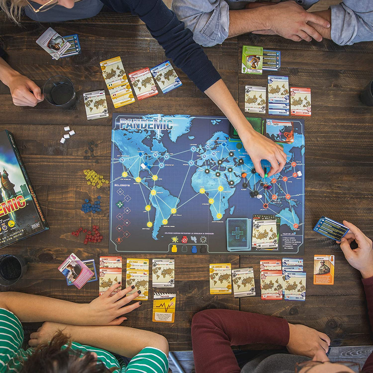 Players collaborating to cure diseases on a world map in the cooperative board game Pandemic.