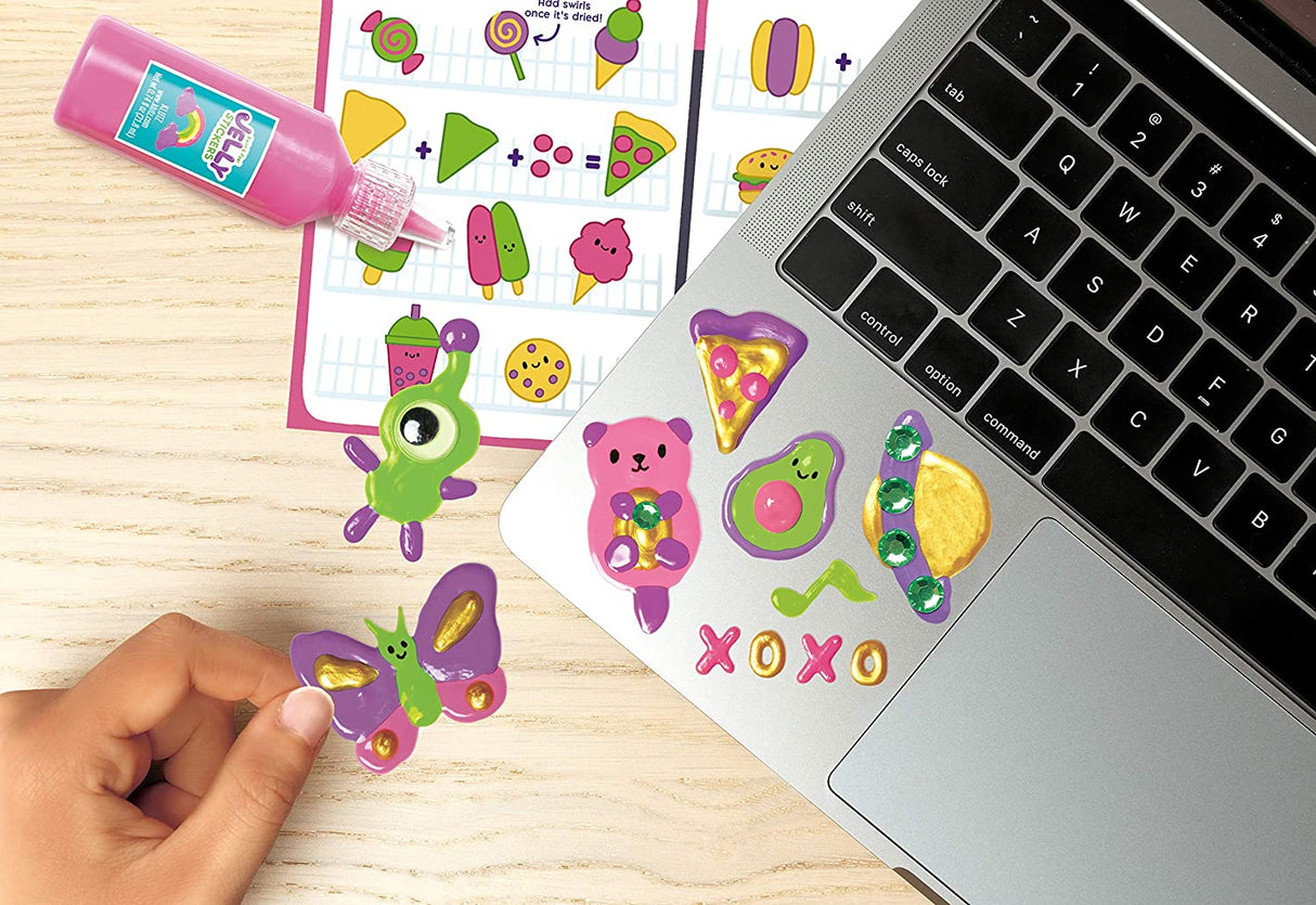 Paint & Peel Jelly Stickers being decorated with rhinestones and applied to a laptop keyboard edge.